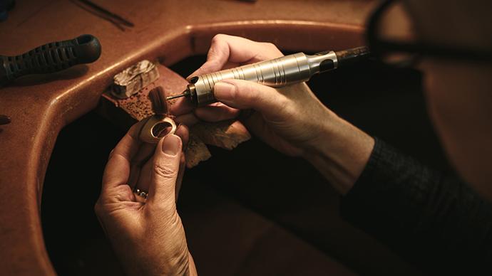 Closeup of a woman's hands as she polishes a ring